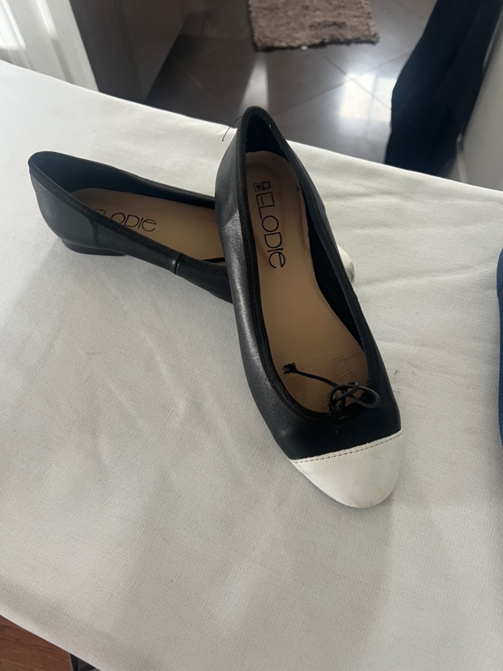 Elodie Black Flats with White Cap Toe and Bow Accent